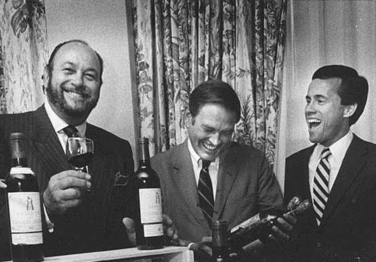 Black and white photos of men holding wine bottles