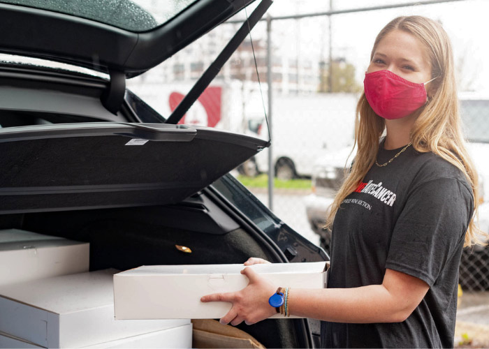 Girl placing boxes in back of car